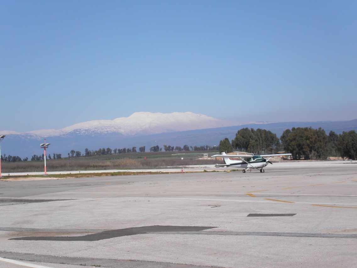 Taken in Rosh Pina Airport (LLIB), view of an Cessna 172 airplane with the Hermon Mountain full of snow on the background
